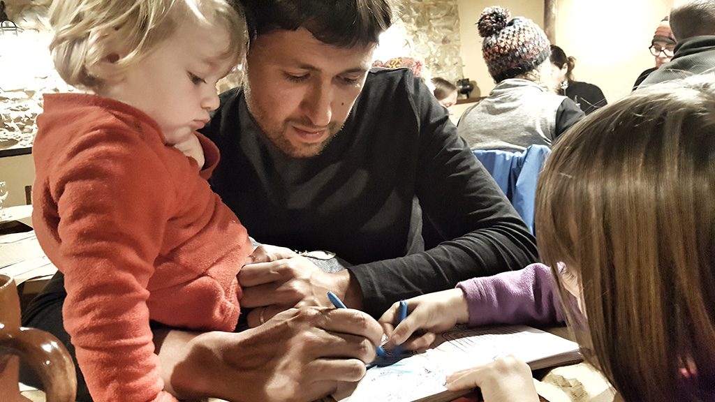 Hombre con niñas pintando en un mantel Hombre con niñas pintando en un mantel