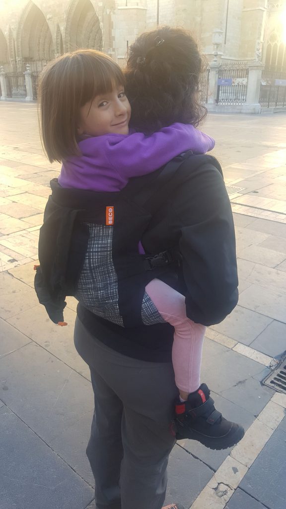 Mujer porteando a niña de 5 años Mujer porteando a niña de 5 años
